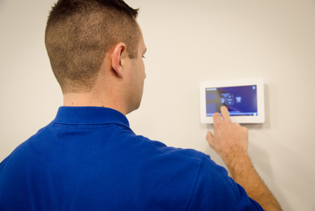 Technician checking a customer's thermostat settings after completing furnace repair.