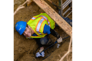 Worker in vest and hard hat underground, smiling