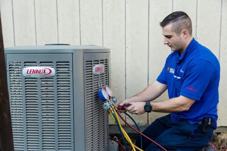 Arctic tech testing the refrigerant on an HVAC unit