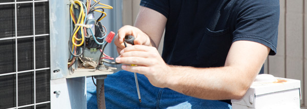 AC technician repairing an air conditioner