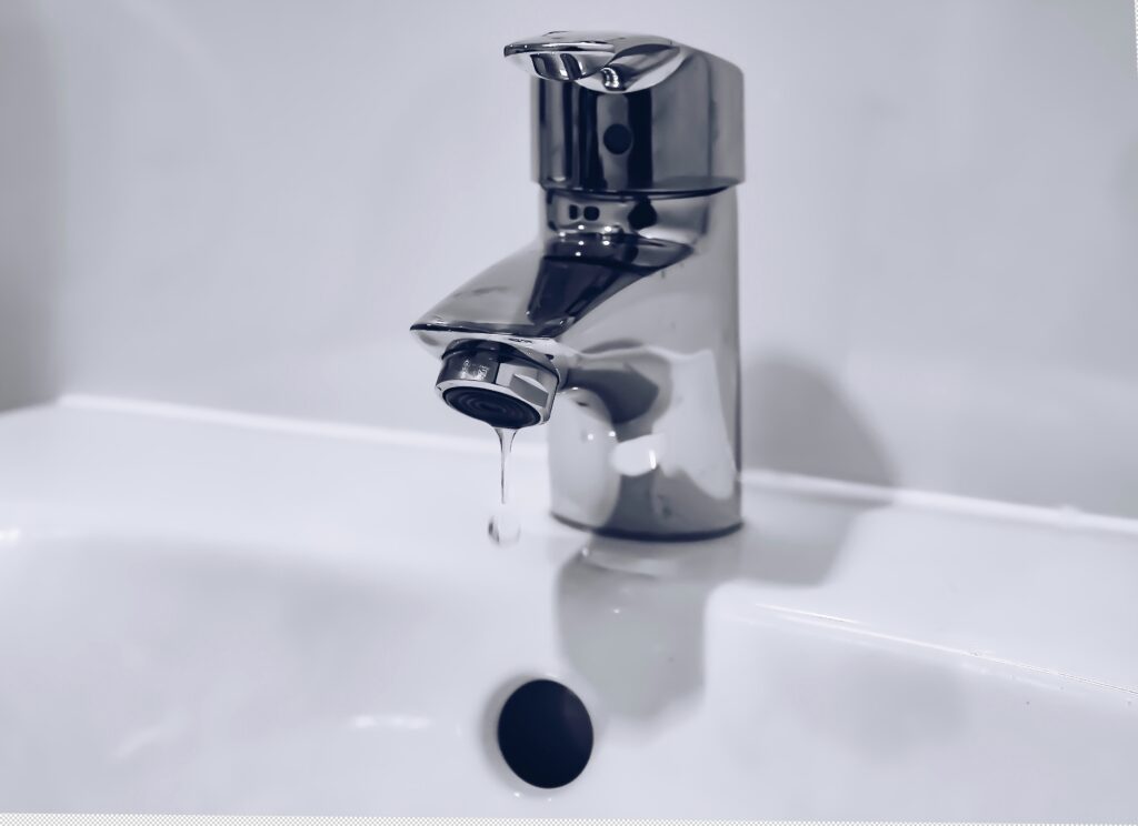 Dripping faucet with white sink