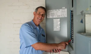 Electrician checking the voltage at the terminals of the electrical meter. They are using a multimeter.